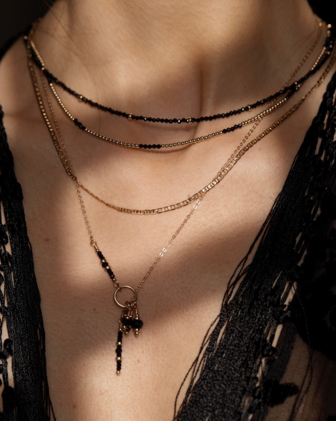 Layered gold and black gemstone necklaces