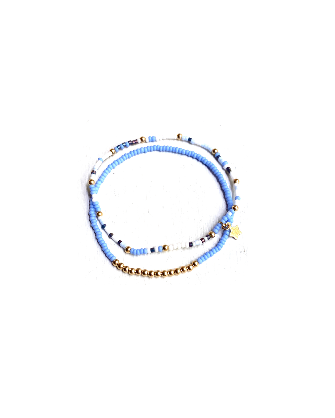 Set of two blue and white gold glass beaded glass beaded bracelets on a white background