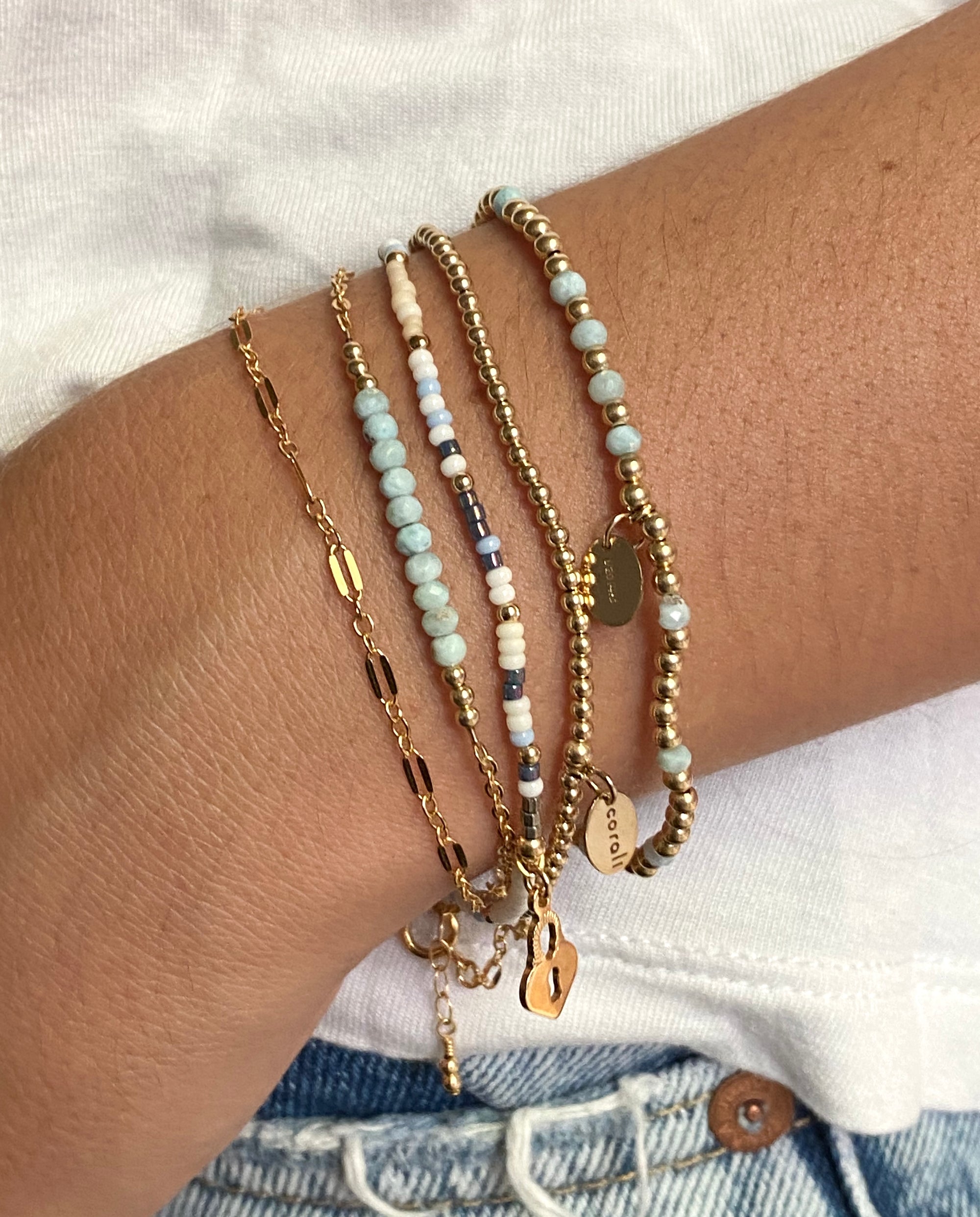 Multiple bracelets on a wrist with a blurred background