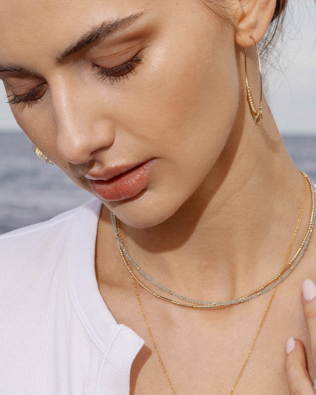 Close-up of a woman wearing gold jewelry with a blurred background