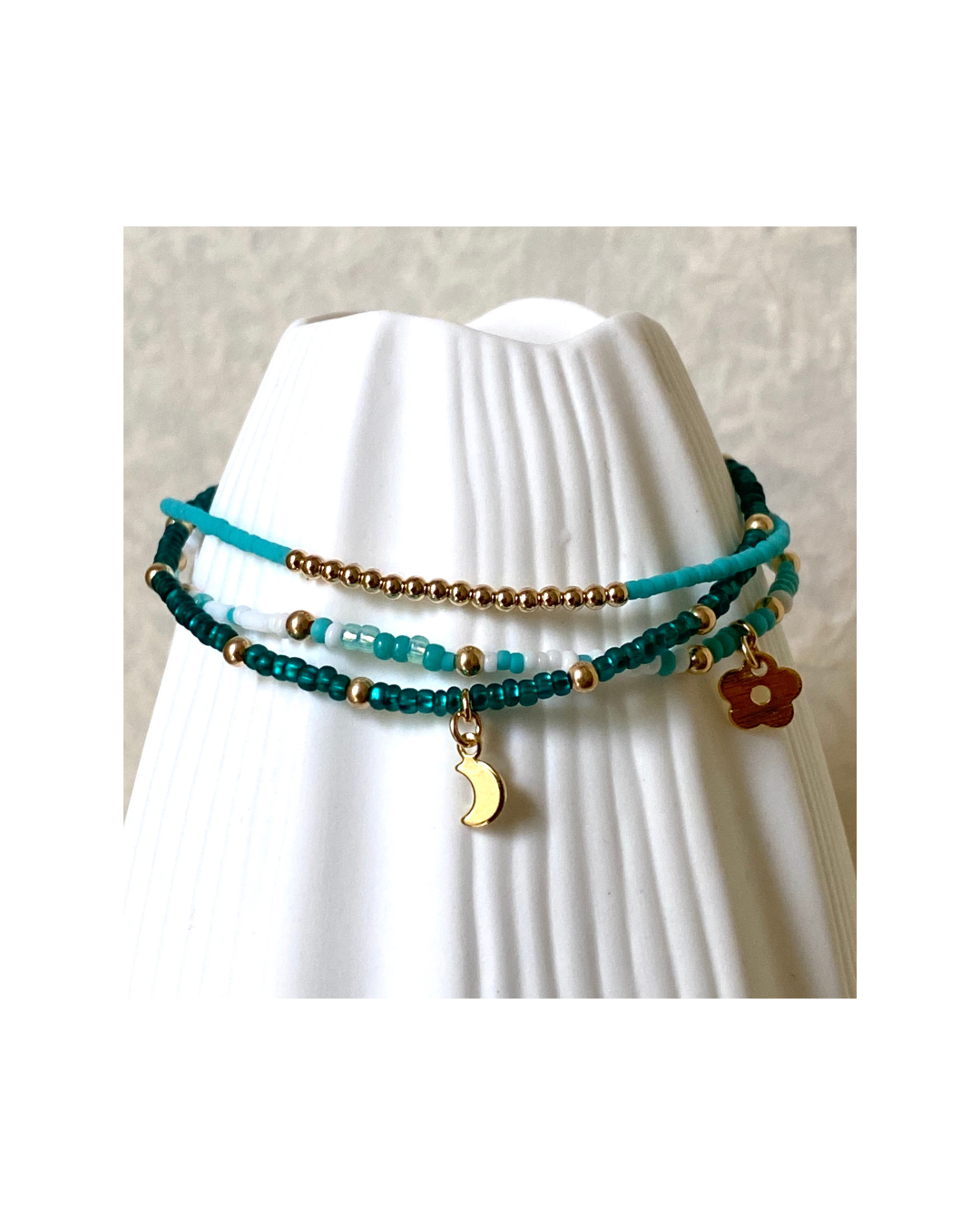 Turquoise beaded bracelet with gold accents on a white mannequin.