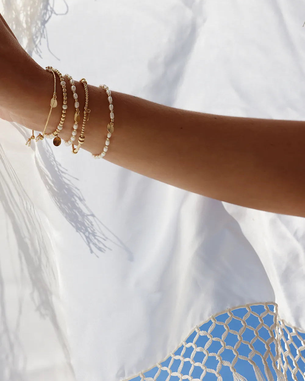 Close-up of a wrist wearing a bracelet with freshwater pearls paired with 14kt gold-filled beads.