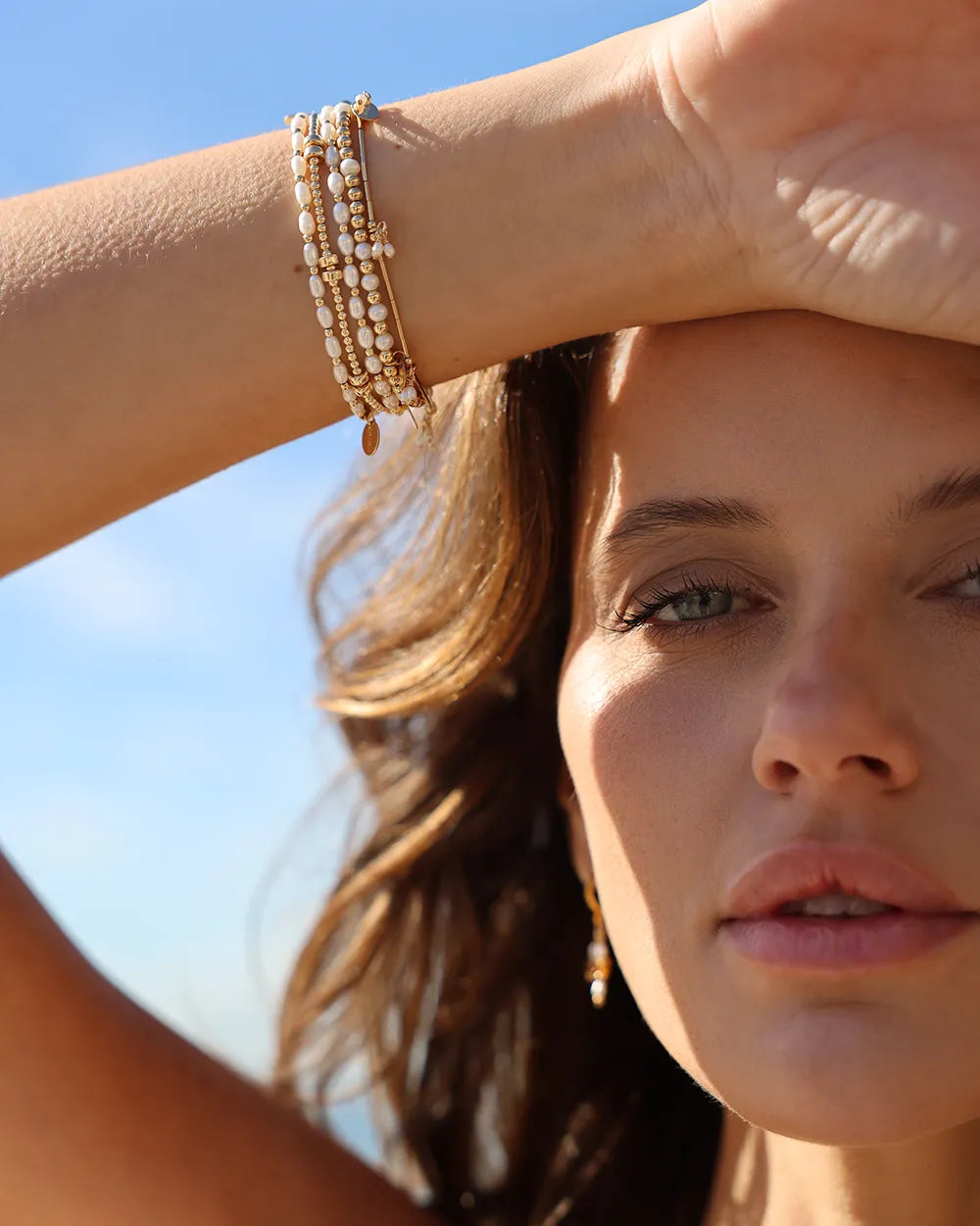 Close-up of a wrist wearing a bracelet with freshwater pearls paired with 14kt gold-filled beads.