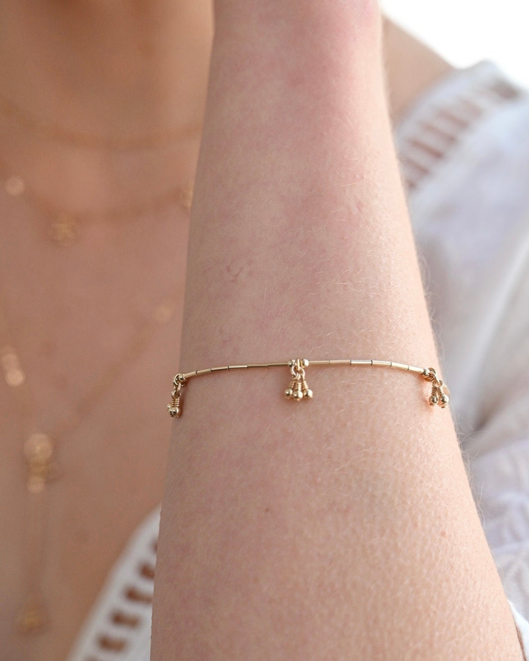 Gold bracelet on a wrist with a blurred background