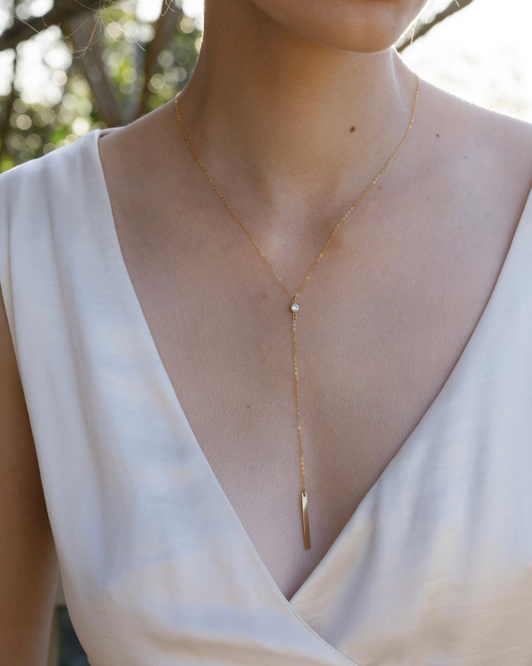 Close up of a bride wearing a Gold and Cubic Zirconia gemstone lariat necklace 
