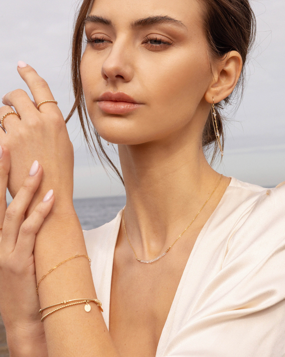 Woman wearing gold jewellery with a blurred background
