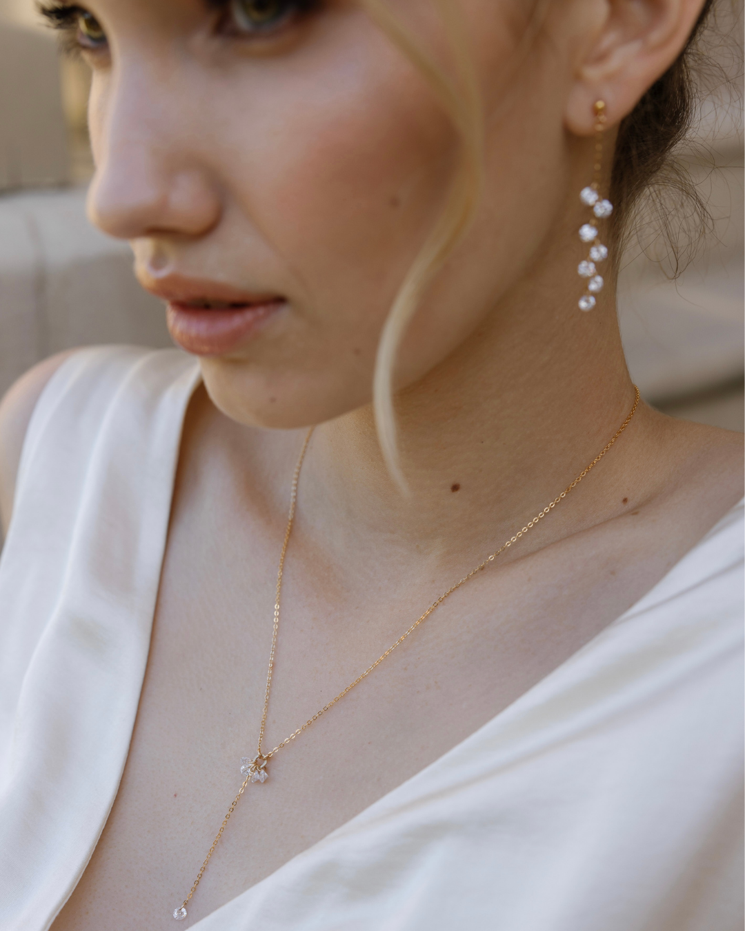 Close-up of a bride wearing a gold and Cubic Zirconia Drops earrings and necklace.