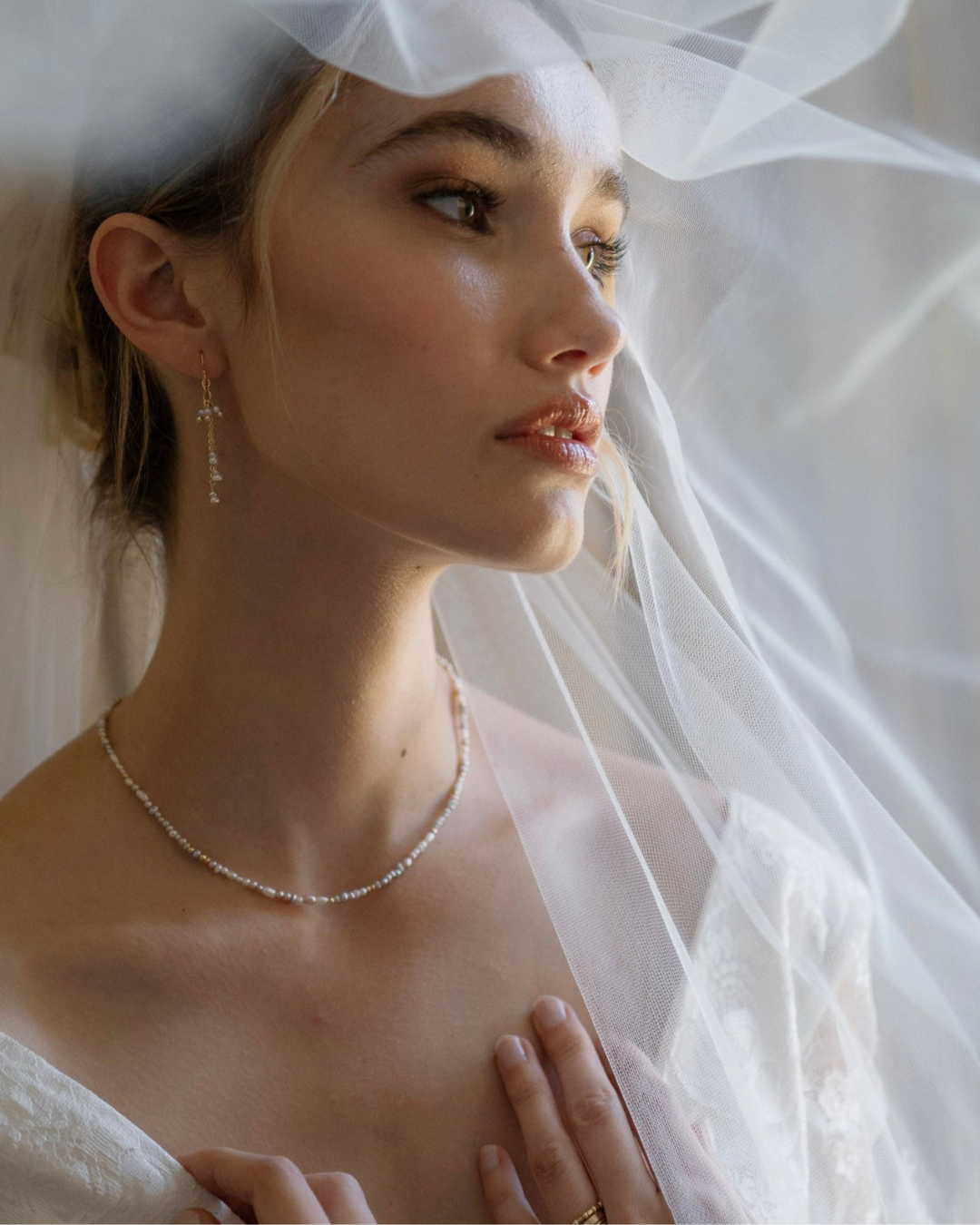 Bride wearing a white wedding dress with a veil and jewelry