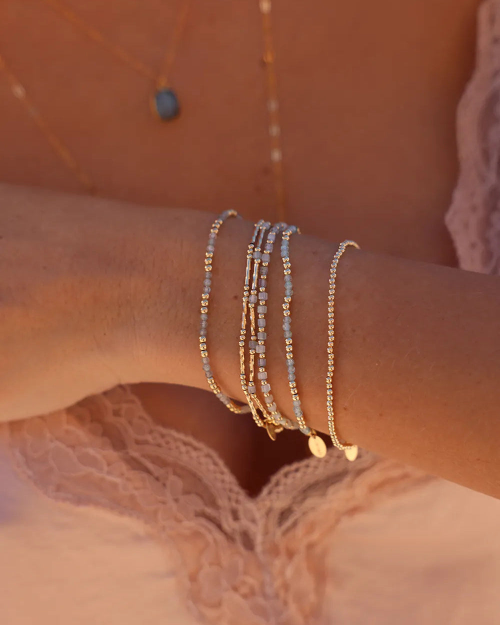 Model wearing bracelet featuring soft blue Aquamarine cube gemstones paired with a mix of round and corrugated tube-shaped beads