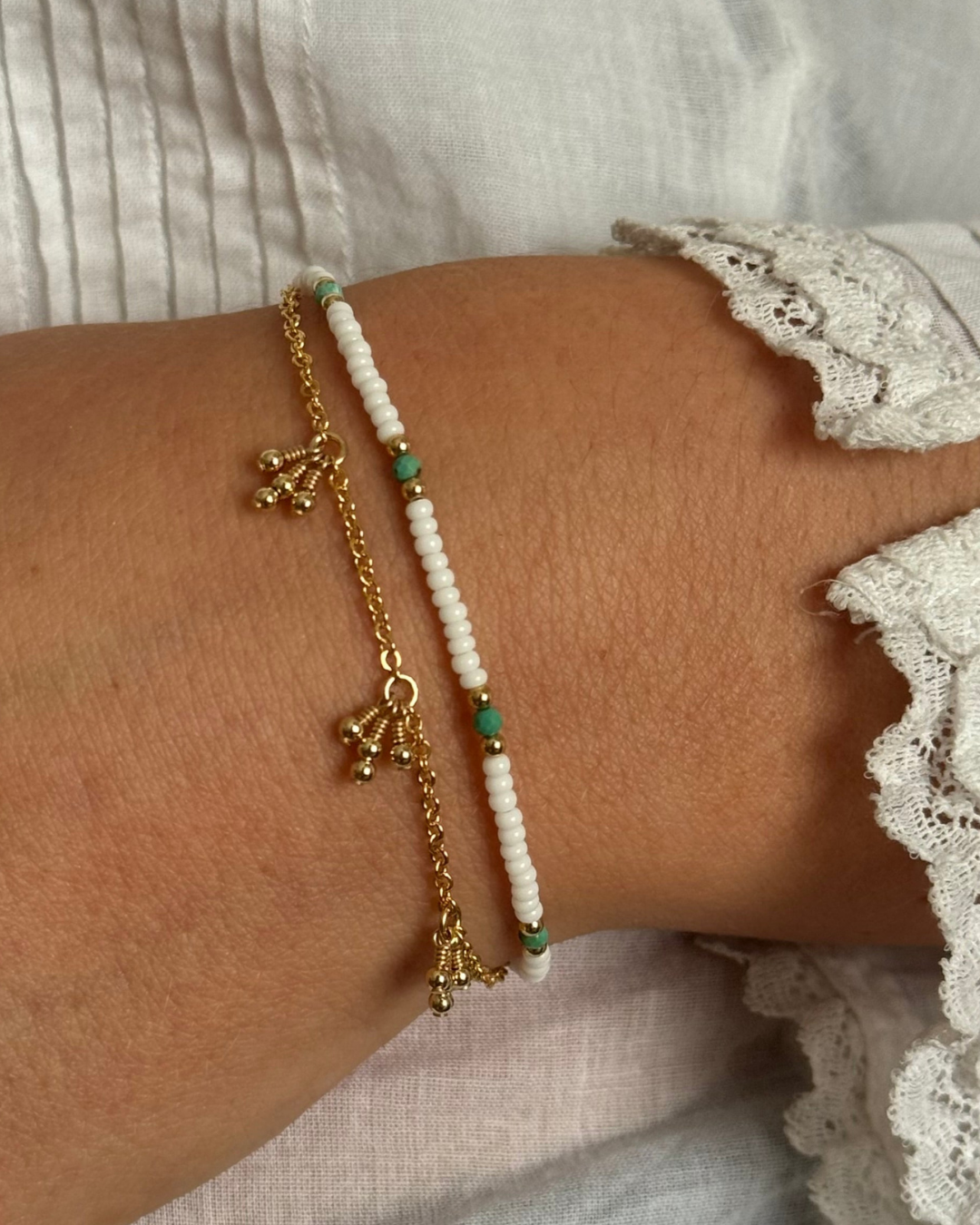Close-up of a wrist wearing two bracelets with a soft background