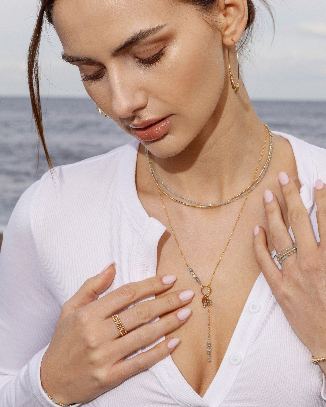 Woman wearing gold jewelry with a blurred background