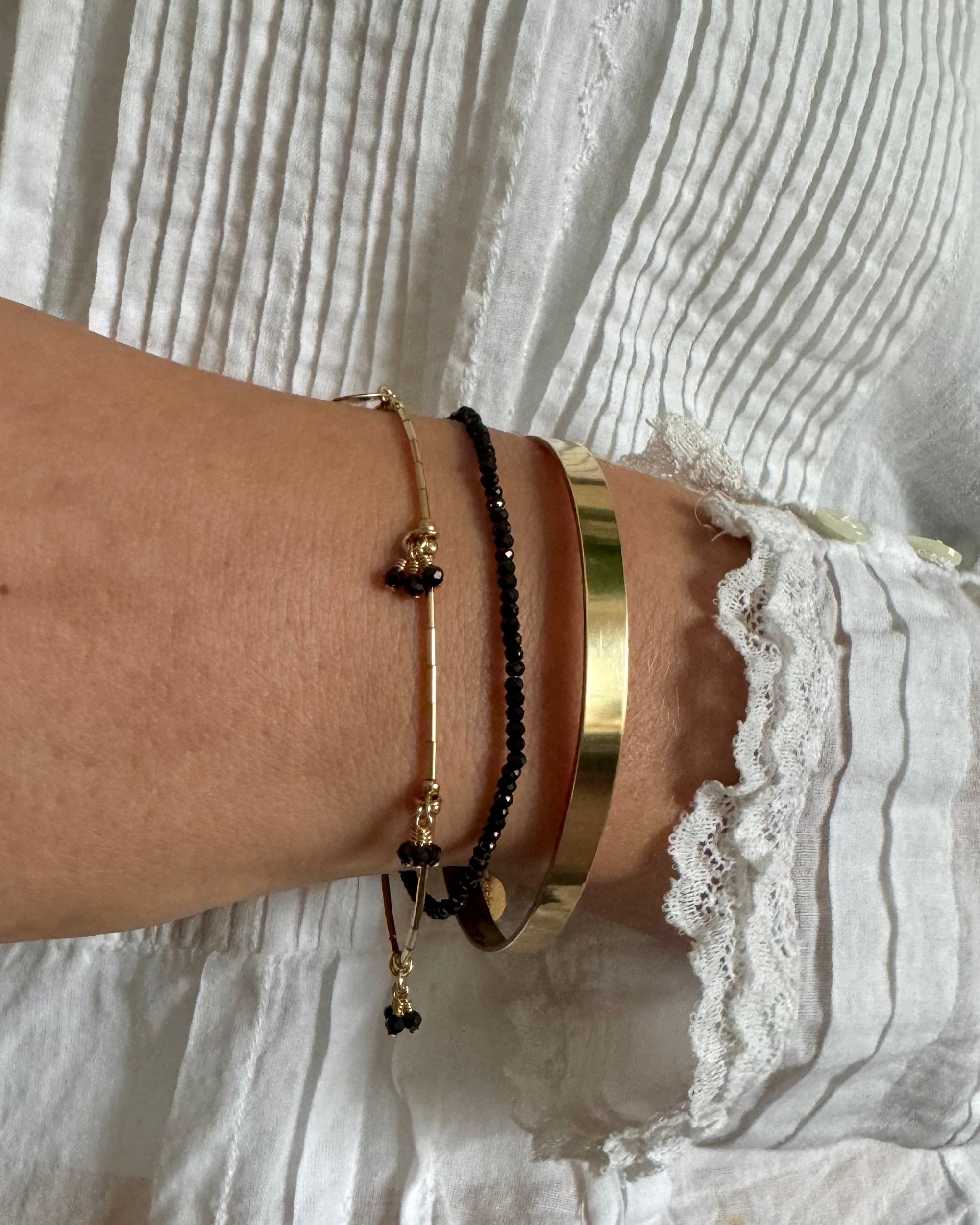 gold beaded bracelet with black spinel