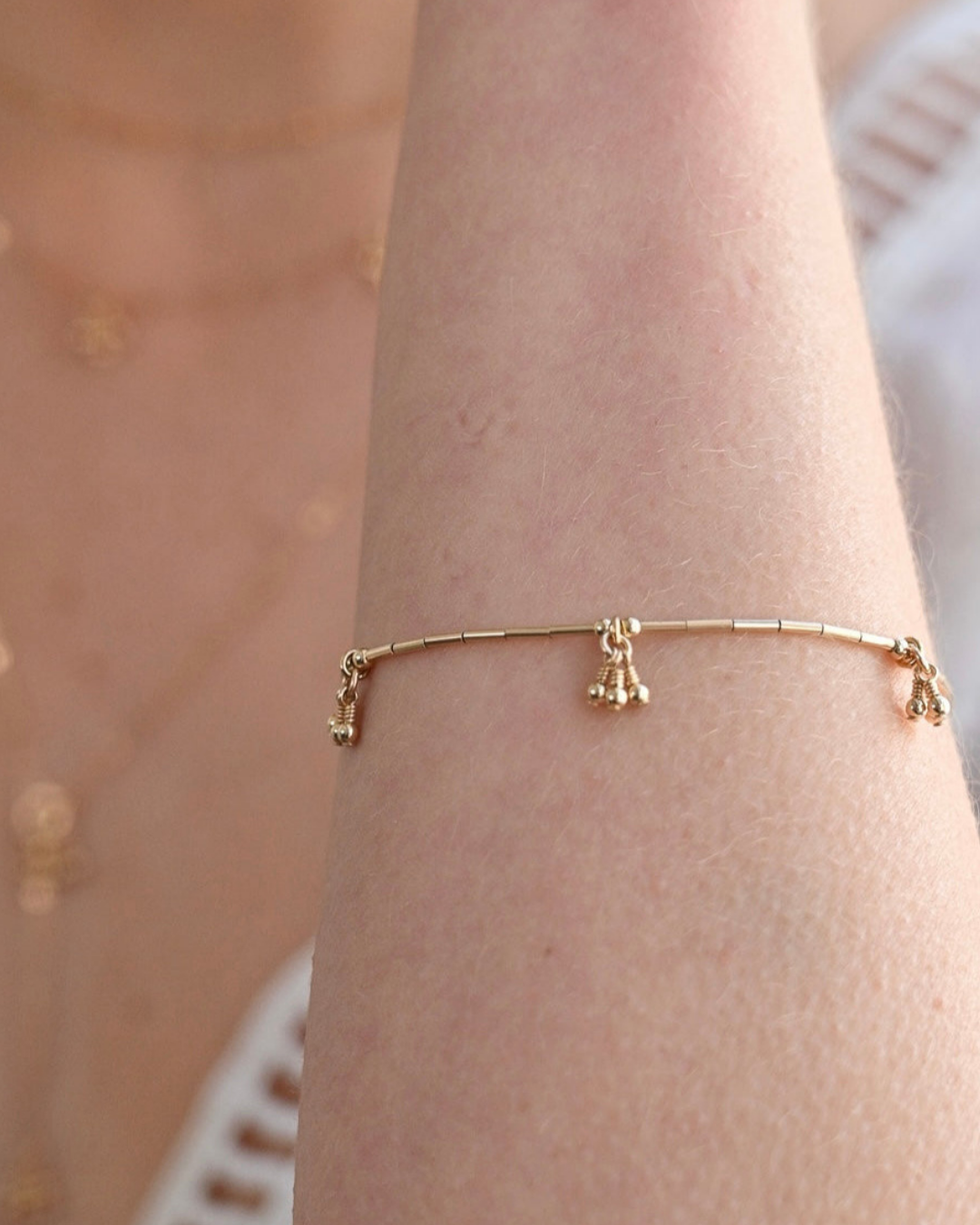 Gold bracelet on a wrist with a blurred background