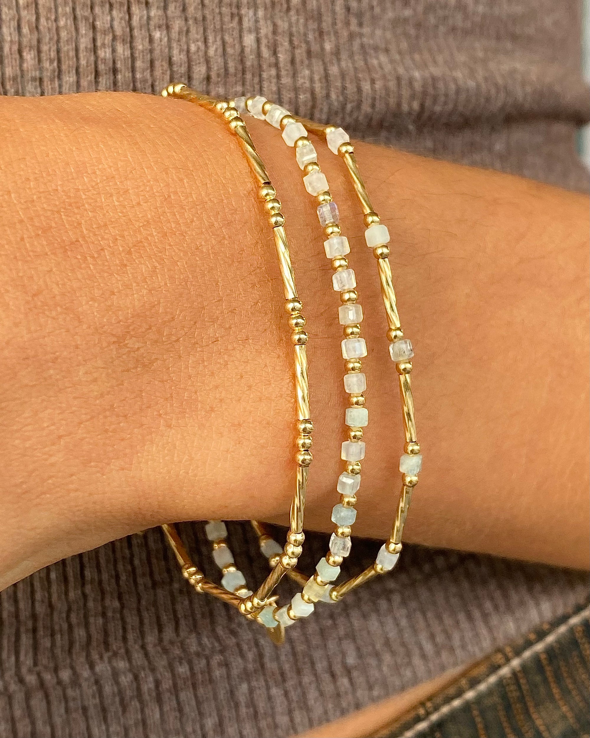 Beaded bracelets on a wrist with a neutral background