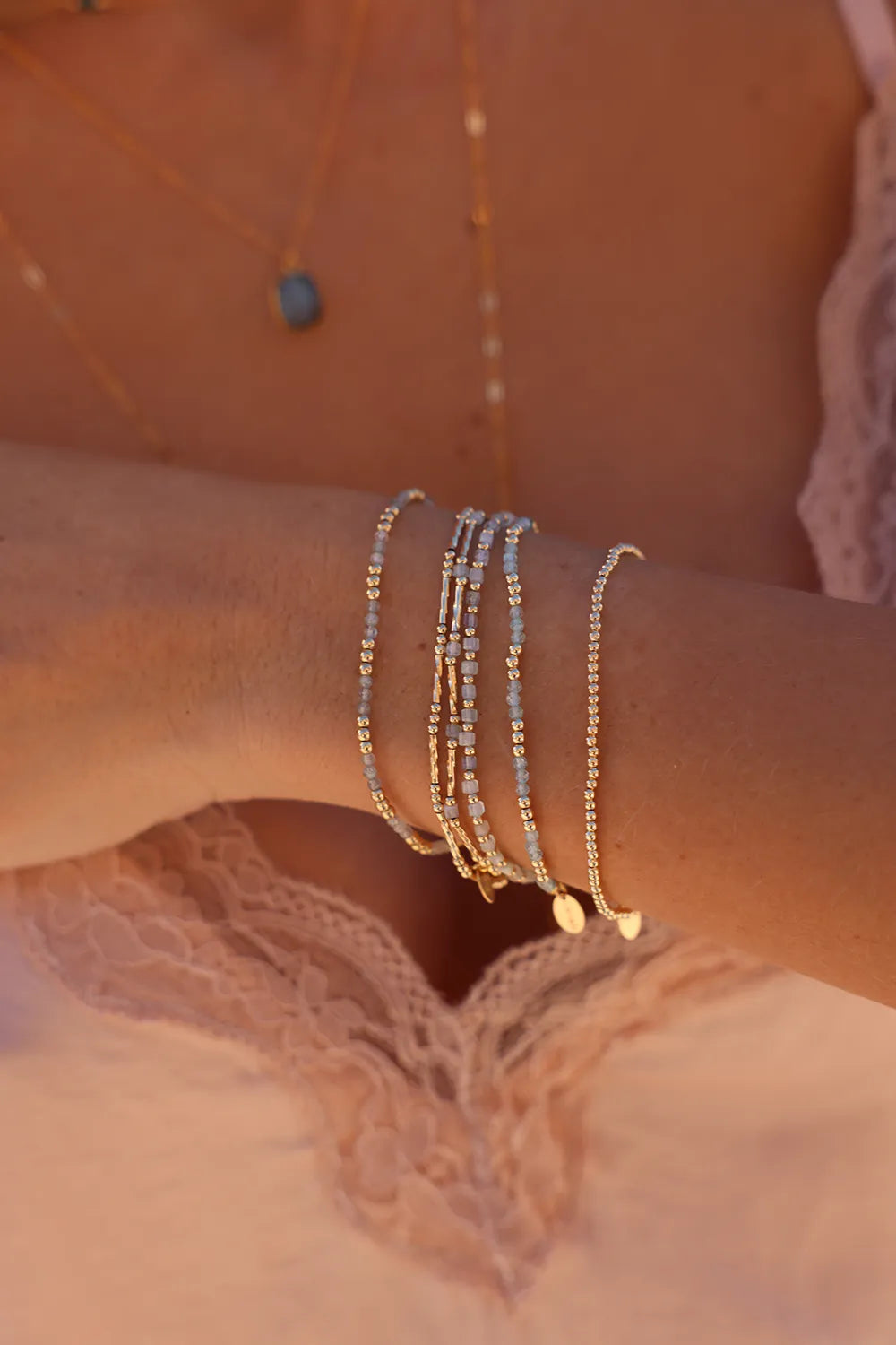 Model wearing bracelet with a mix of round and corrugated tube-shaped beads hand-strung onto durable elastic cord
