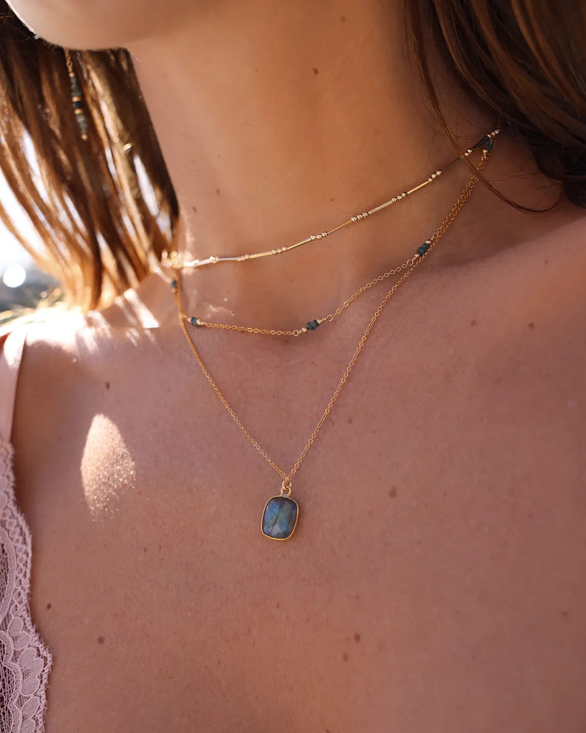 Model wearing Labradorite gemstone pendant, suspended from a delicate gold cable chain