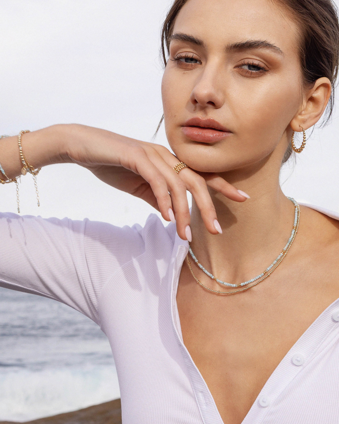 Woman wearing a necklace with a blurred beach background
