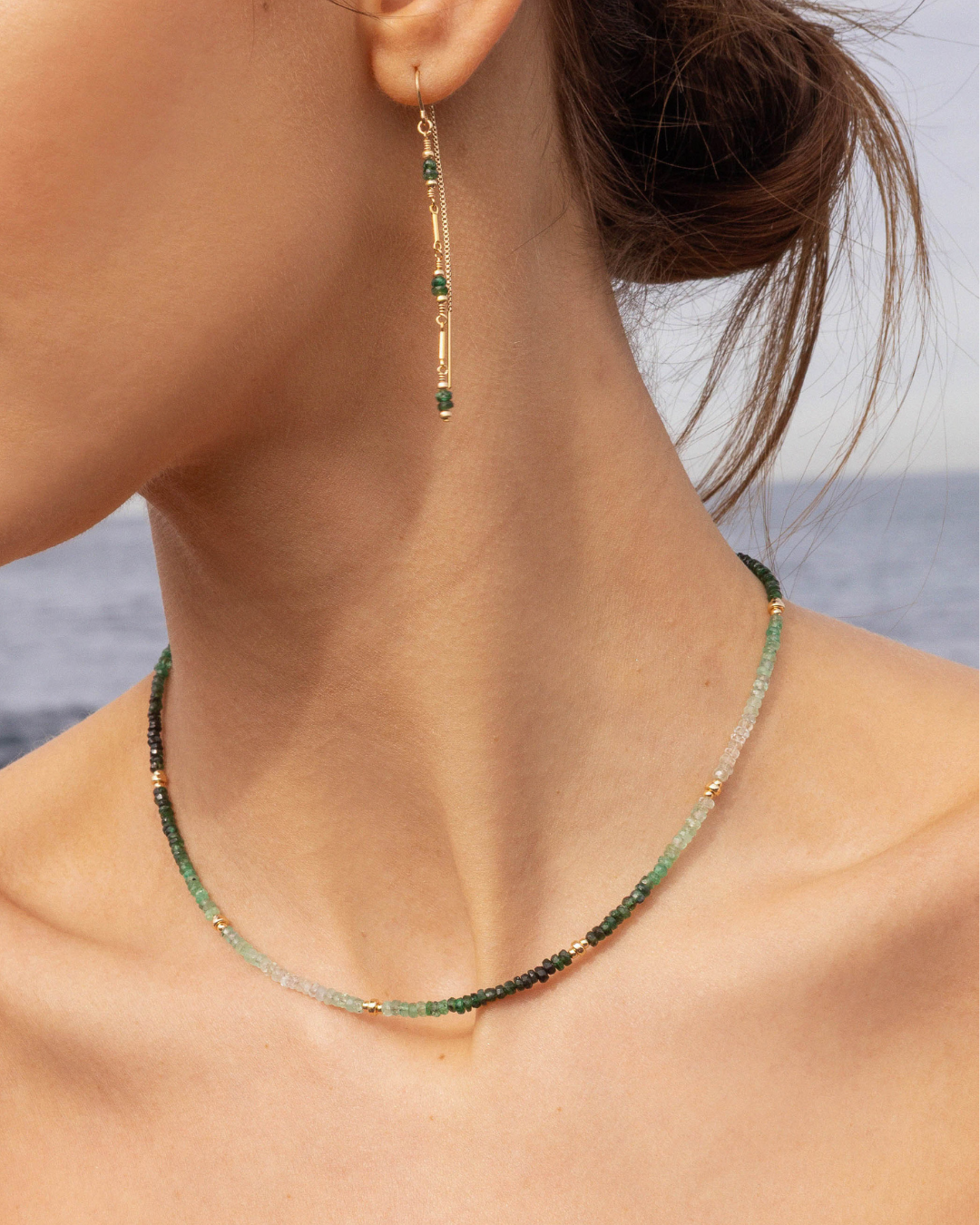 Necklace and earrings on a person with a blurred background