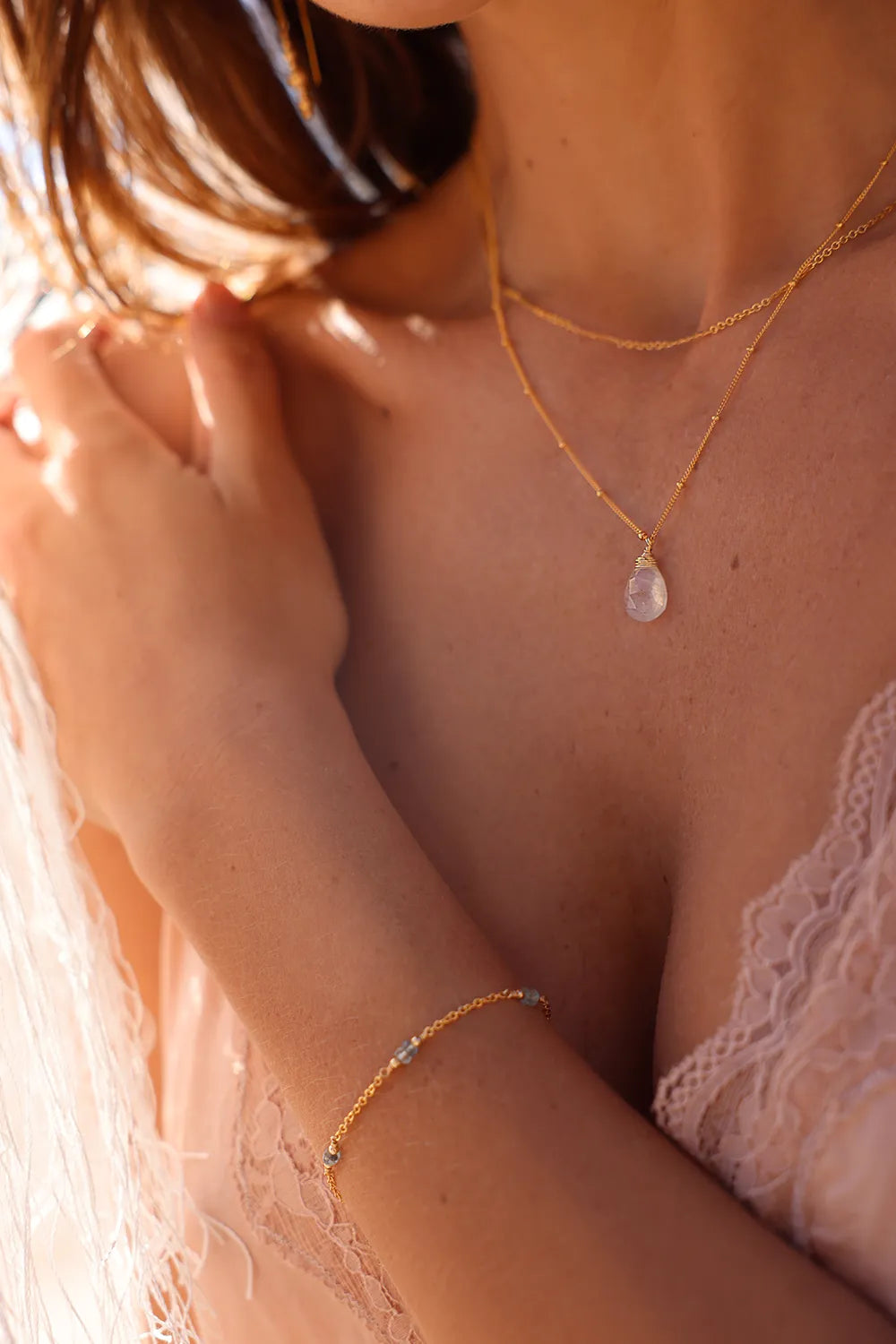 Model wearig delicate gold aquamarine beaded bracelet