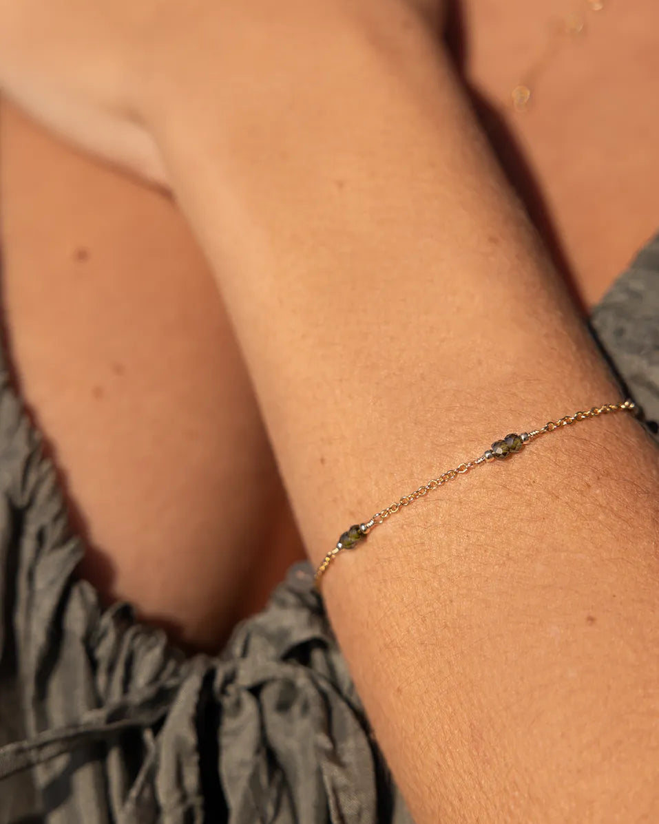 Gold bracelet, featuring dark green Zircon beads.