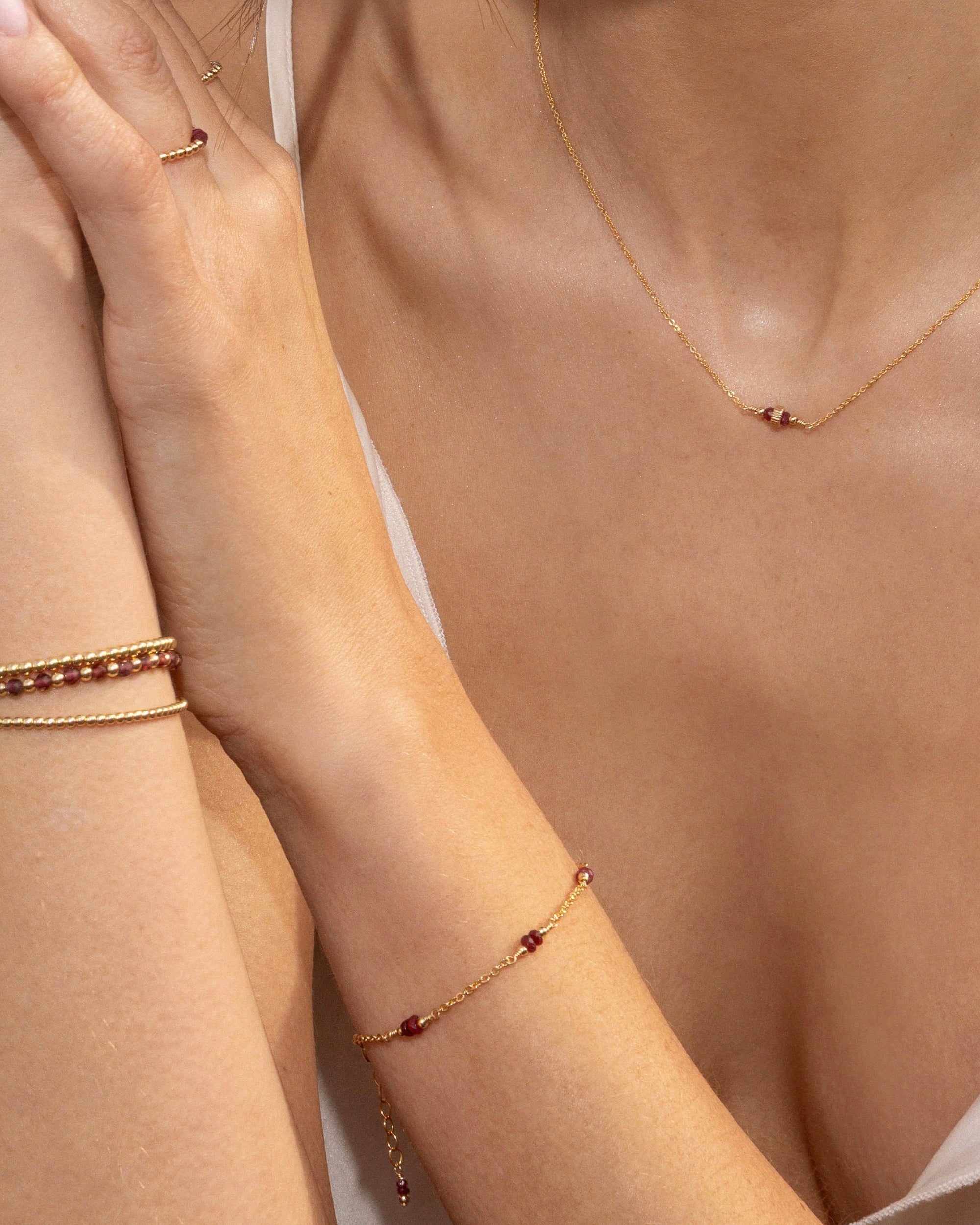 Woman wearing gold and ruby jewelry.