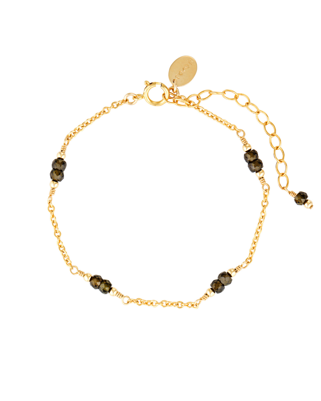 Gold bracelet with dark zircon beads on a white background