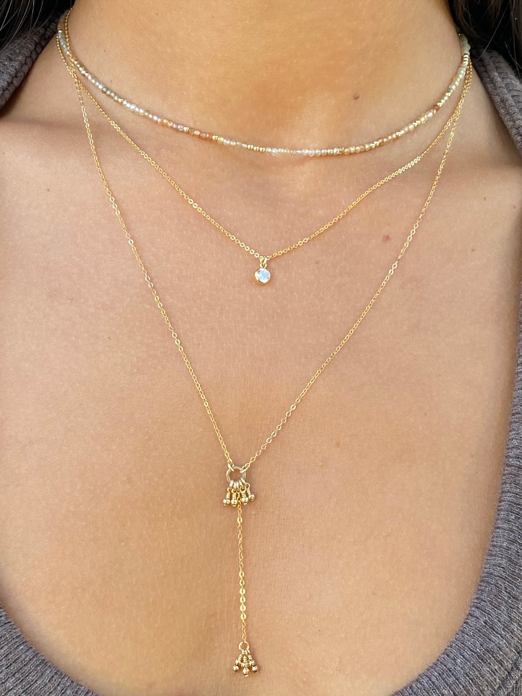 Close-up of a person wearing two gold necklaces