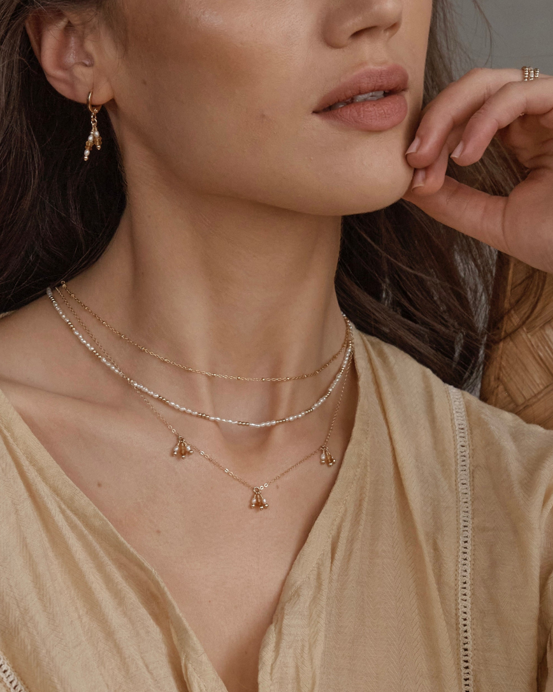 Close up of neck with layered necklaces.