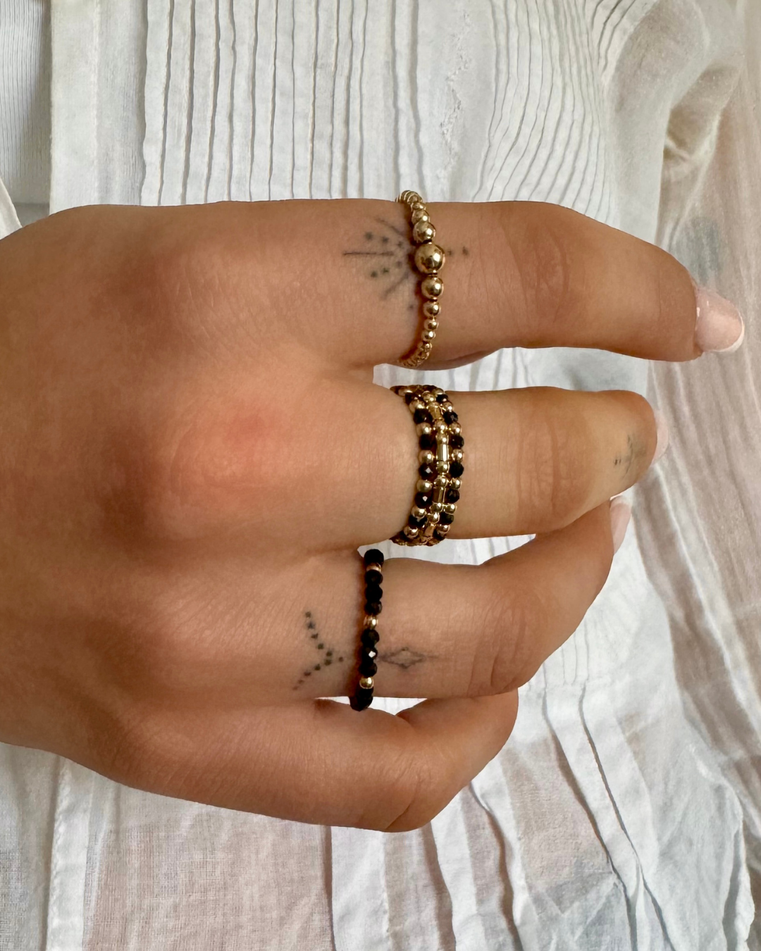Close up of layered rings of gold and black beads.