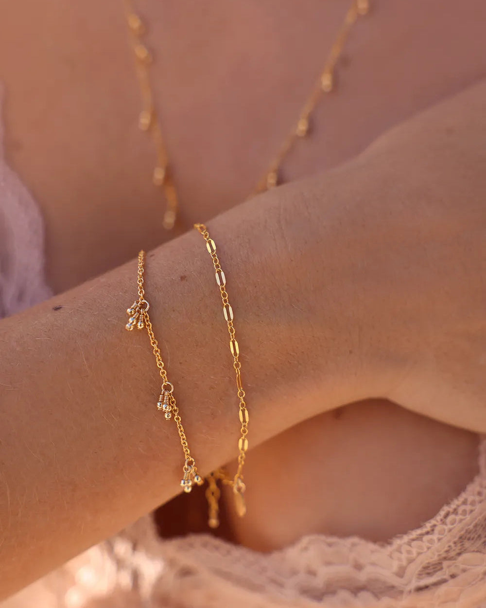 Close-up of a person's wrist wearing a dainty bracelet with fine gold links