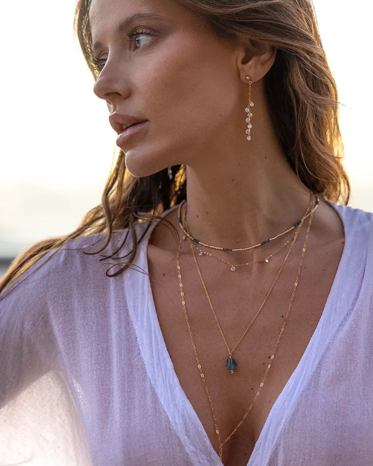 Model wearing Gold necklace with cubic zirconia gemstones