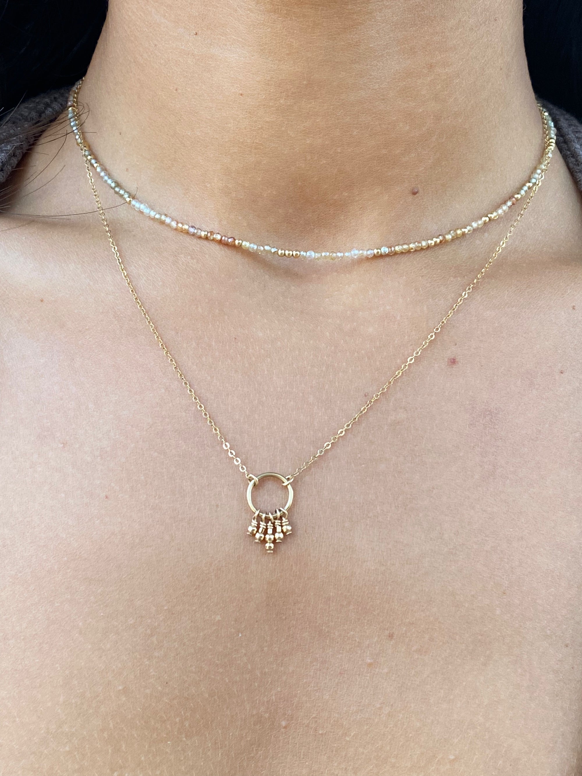 Hand wire-wrapped golden beads suspended from a circle on a gold chain
