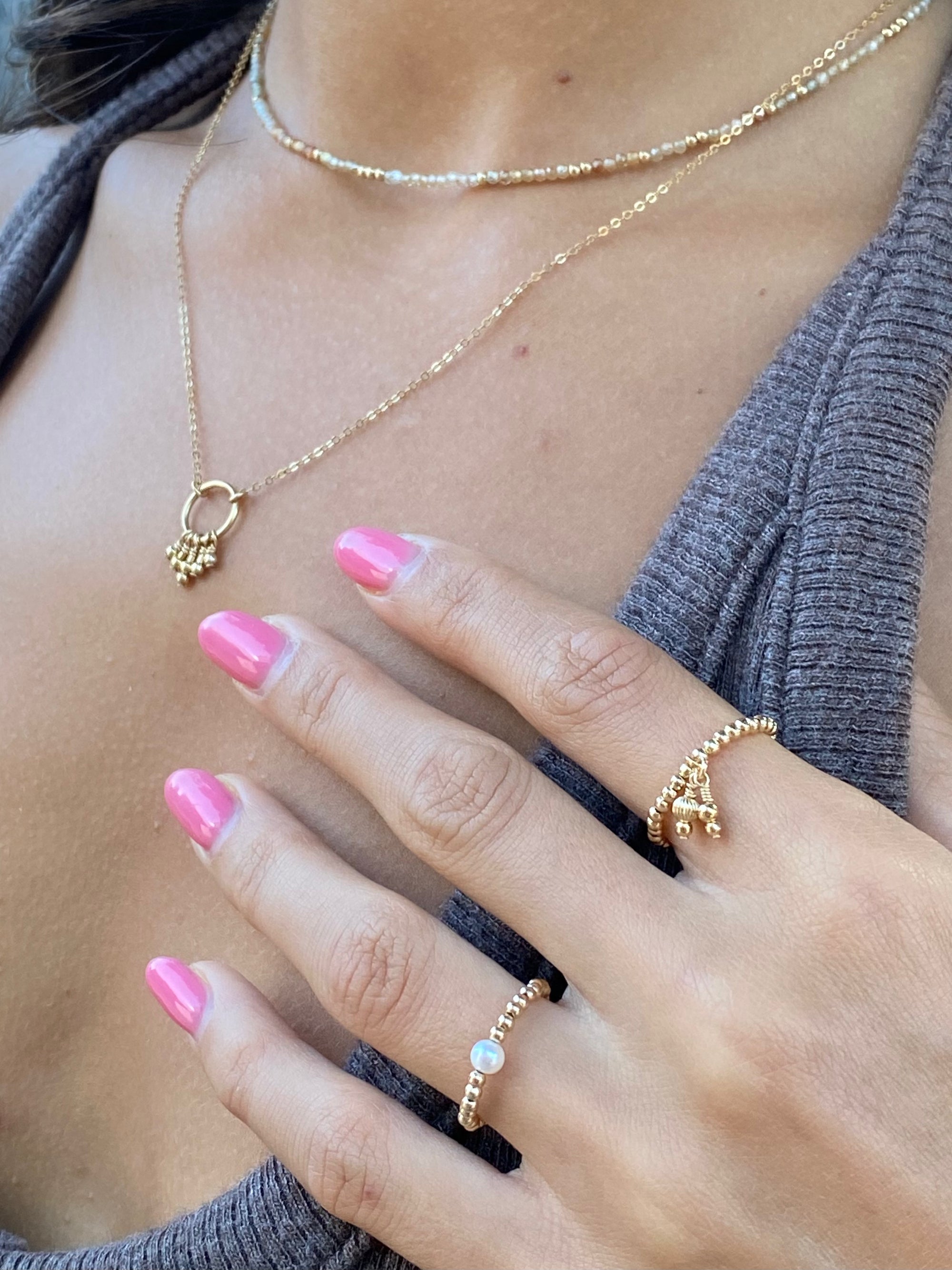 Hand wire-wrapped golden beads suspended from a circle on a gold chain