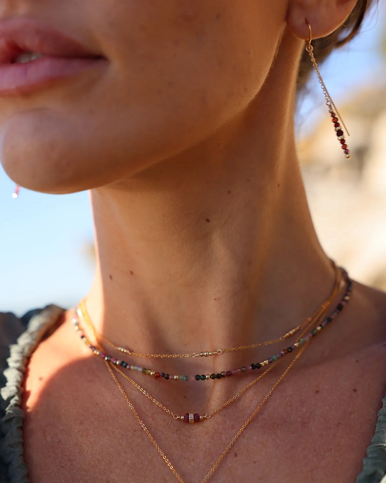 Model wearing Gold chain earrings with Garnet beads