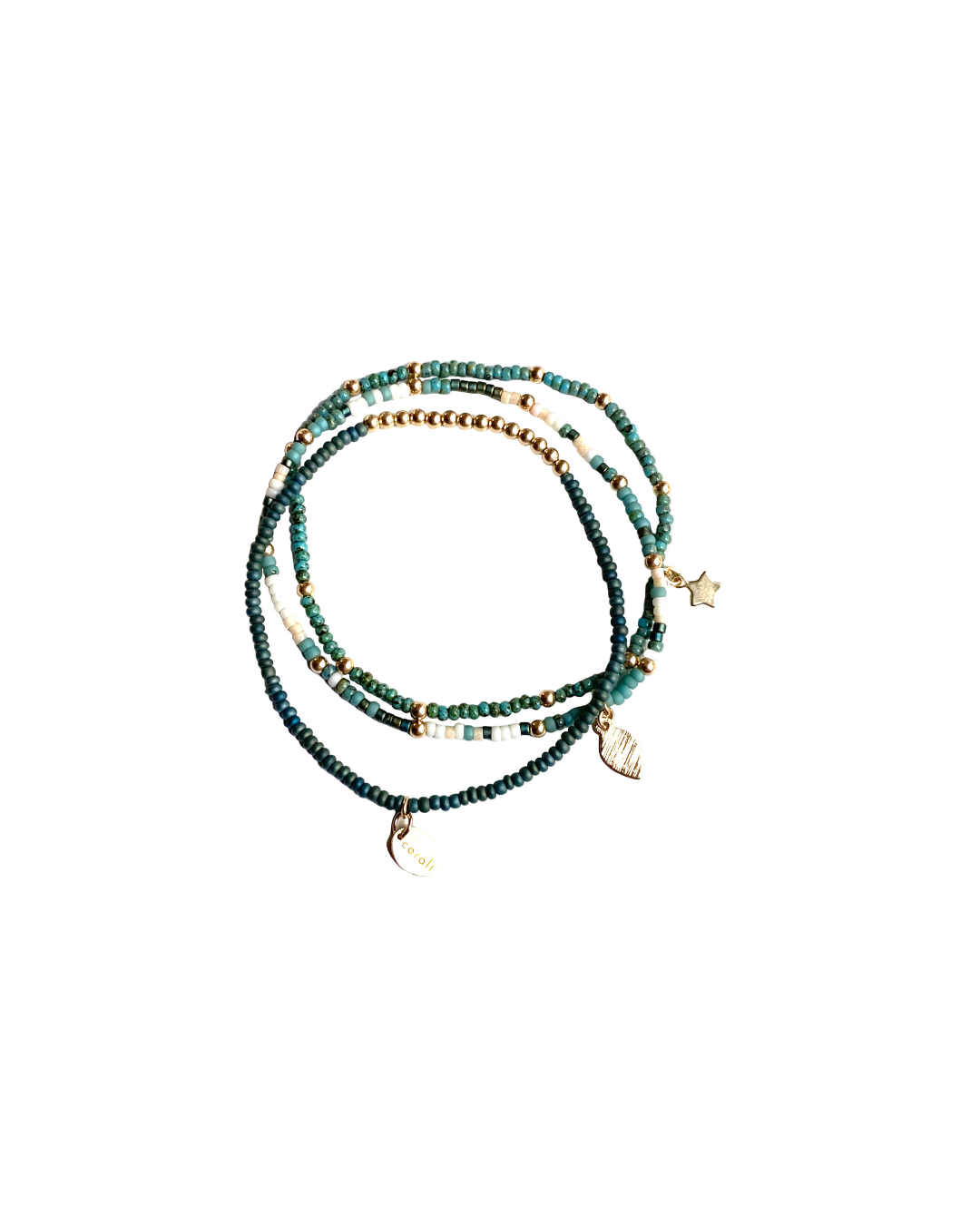 Set of gold and glass beaded bracelets with a star, moon and leaf gold charm on a white background