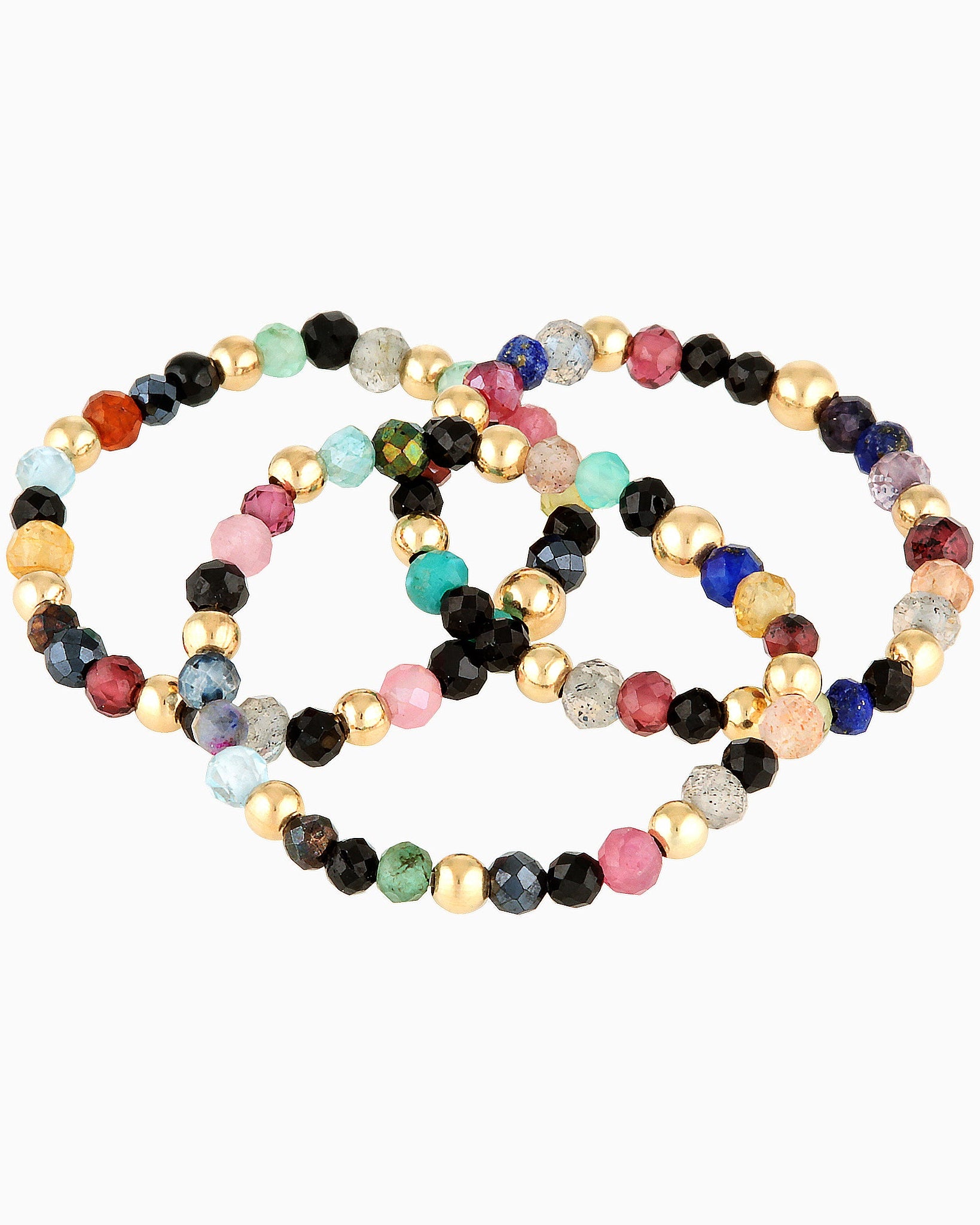 Three multi gemstone gold beaded rings on a white background